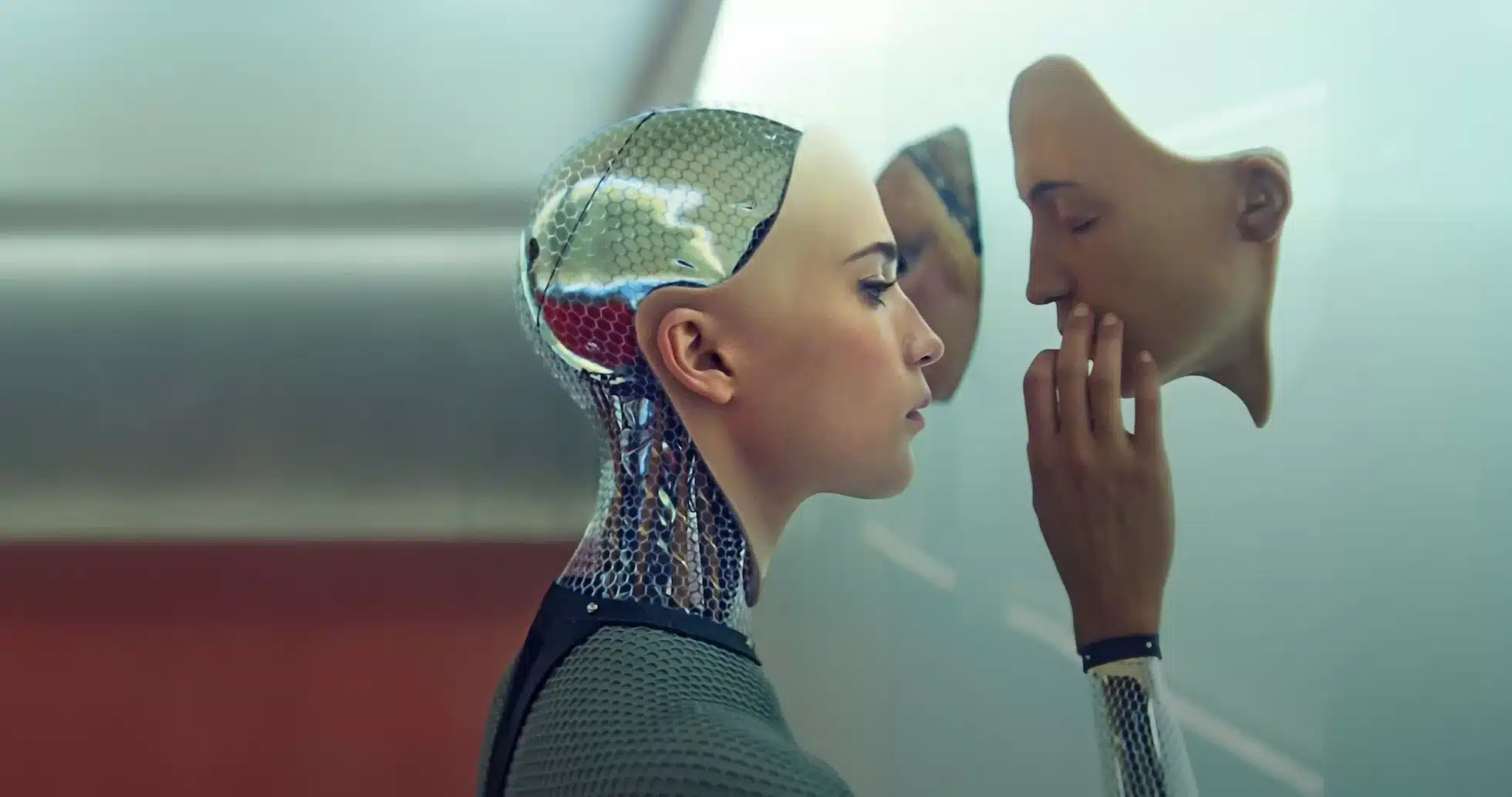 Alicia Vikander como Ava en Ex Machina observa un rostro humano en la pared, metáfora visual de la identidad y la conciencia artificial en el cine de ciencia ficción.