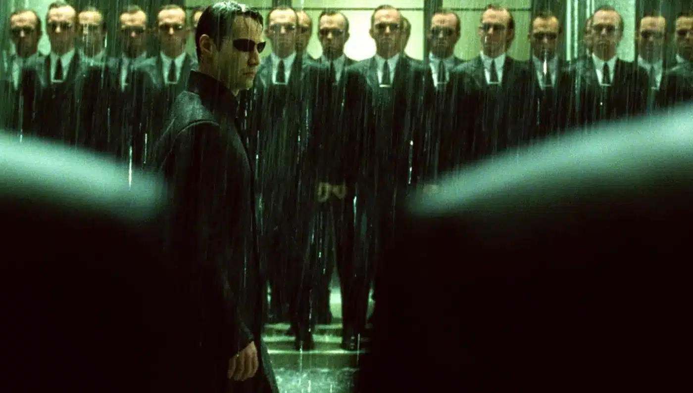 Neo enfrentando a cientos de Agentes Smith bajo la lluvia en Matrix Revoluciones, una escena que simboliza el sacrificio y la elección final.