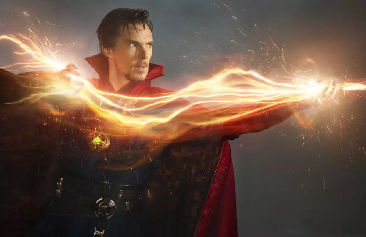 Doctor Strange canalizando un hechizo de energía dorada, con destellos y chispas luminosas alrededor de sus brazos, capa roja en movimiento y expresión concentrada mientras ejecuta magia avanzada del universo Marvel.